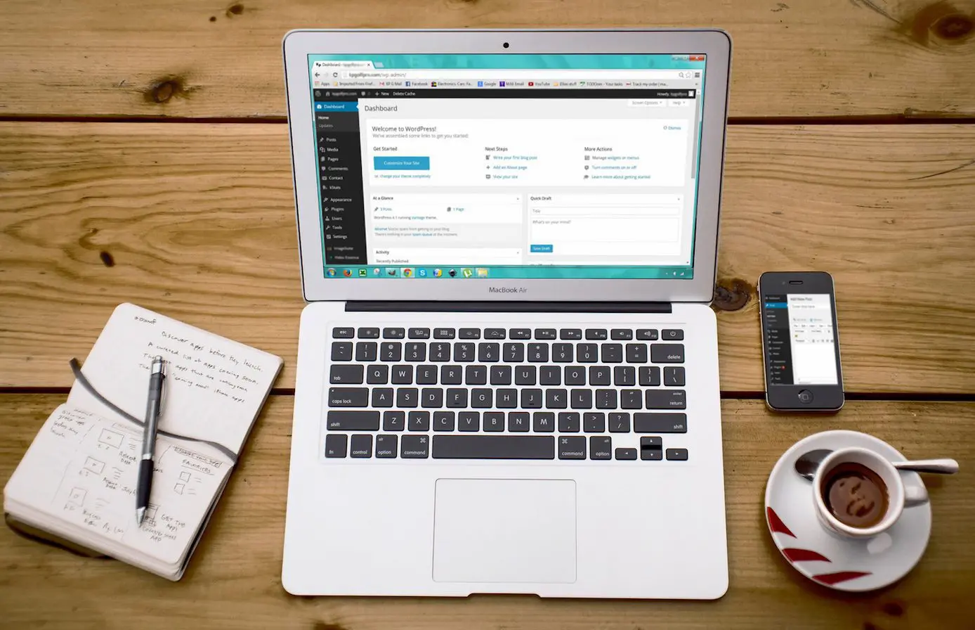 Laptop showing a WordPress dashboard on a wooden desk